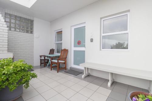 a porch with a bench and a table at South Point Guest Lodge in Agulhas