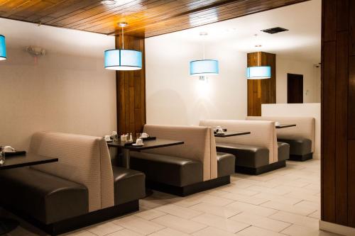 a restaurant with chairs and tables and lights at Holiday Inn Victorville by IHG in Victorville