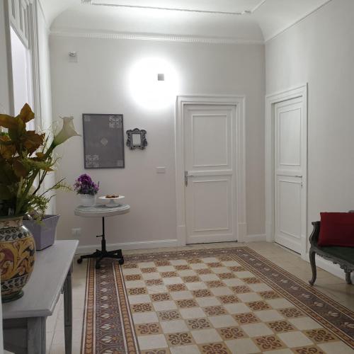 a room with white walls and white doors and a rug at Opera Prima 28 in Palermo