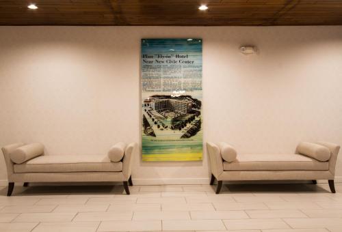 a waiting room with two chairs and a poster on the wall at Holiday Inn Victorville by IHG in Victorville