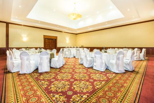a banquet hall with white tables and white chairs at Holiday Inn Convention Center by IHG in Managua
