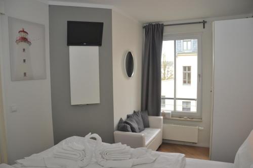 ヘリングスドルフにあるVilla Louiseのベッドルーム1室(ベッド1台、ソファ、窓付)