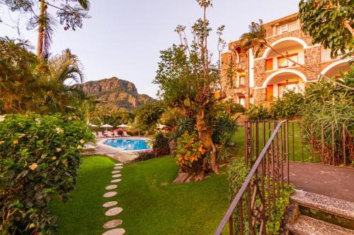 a resort yard with a swimming pool and a building at Posada del Tepozteco - Hotel & Gallery in Tepoztlán