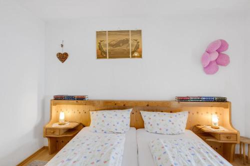 een slaapkamer met 2 bedden en 2 kaarsen aan de muur bij Ferienwohnungen Holzner klein in Inzell