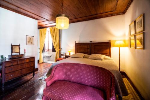a bedroom with a pink bed and a dresser at Casa Nobre do Correio-Mor in Ponte da Barca