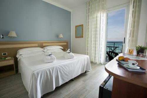 ディアーノ・マリーナにあるHotel Arc En Cielの海の景色を望むベッド付きのホテルルームです。