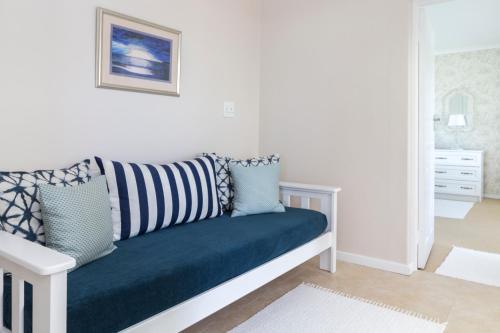 a white living room with a blue couch at South Point Guest Lodge in Agulhas