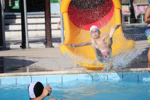 a man sliding down a slide in the water at Club del Sole Stork Family Collection in Giulianova