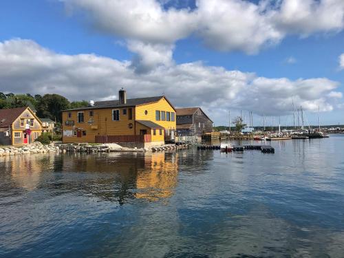 una casa en el agua junto a un muelle con barcos en Harbour Guesthouse, en Clark's Harbour