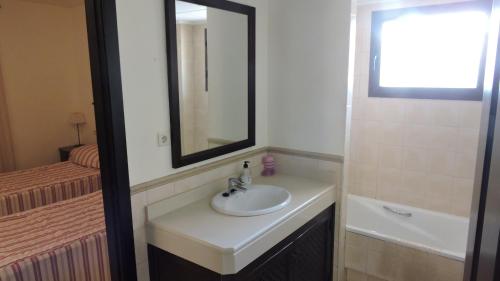 La salle de bains est pourvue d'un lavabo, d'un miroir et d'un lit. dans l'établissement HL 017 ·HL 017 3 bedroom 2 bathroom, villa high standard, à Fuente Alamo