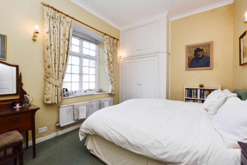 a bedroom with a white bed and a window at The Old School in Bicester