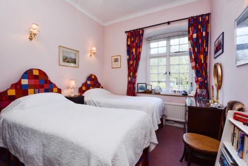 a bedroom with two beds and a window at The Old School in Bicester