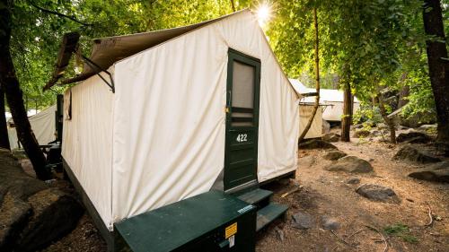 a small white tent with a green door at Curry Village in Curry Village