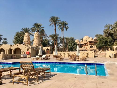 un complejo con piscina y palmeras en Djorff Palace en Luxor