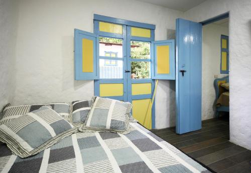 sypialnia z łóżkiem z niebieskimi i żółtymi drzwiami w obiekcie Casa La Maria Salento, w mieście Salento