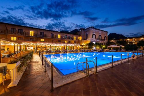 ein großer Swimmingpool in der Nacht mit Lichtern in der Unterkunft Hotel Antico Monastero in Toscolano-Maderno