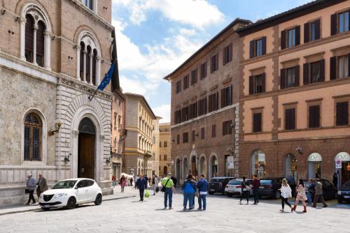 a group of people walking down a street in a city at Domus Nannini SPA - L' Arco di Matteotti in Siena