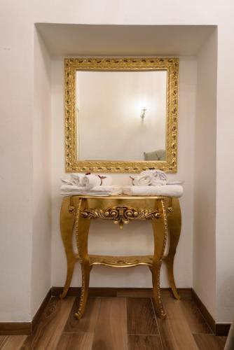 a bathroom with a gold mirror and a sink at Domus Nannini SPA - L' Arco di Matteotti in Siena