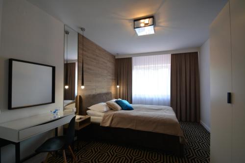 Pokój hotelowy z łóżkiem, biurkiem i oknem w obiekcie Willa Wiesia Rabka Zdrój w Rabce