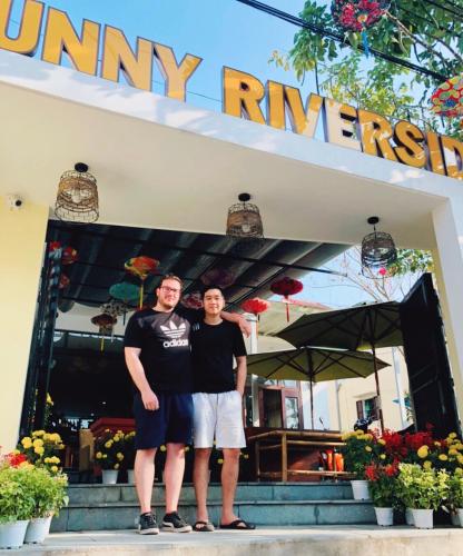 two men are standing in front of a store at Sunny Riverside Homestay in Hoi An