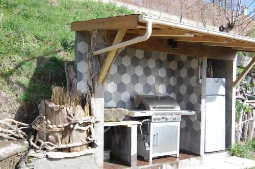 an outdoor kitchen with a stove and a checkerboard wall at Chambre d'hôtes couvent d'Alando in Alando
