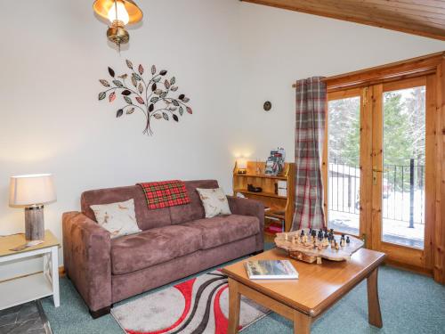 a living room with a couch and a table at Torbreck Chalet in Kingussie