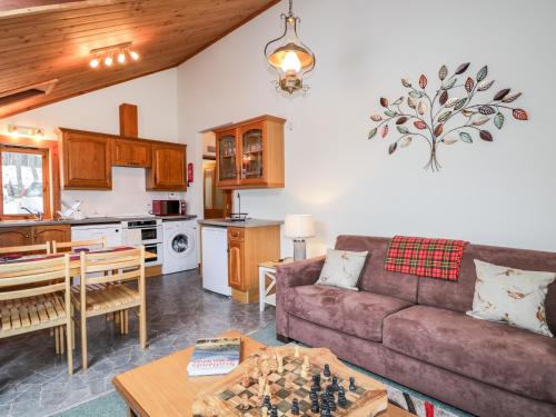 a living room with a couch and a table at Torbreck Chalet in Kingussie