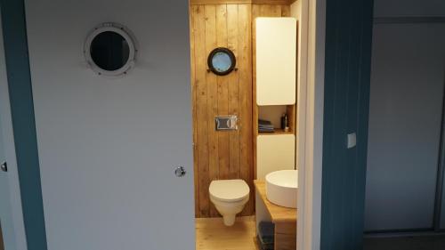 a bathroom with a toilet and a sink at Dom na wodzie nad Jeziorem Krzywe in Piecki