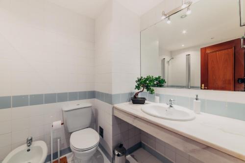 a bathroom with a toilet and a sink and a mirror at Funchal Lounge Apartment by Amazing Madeira in Funchal