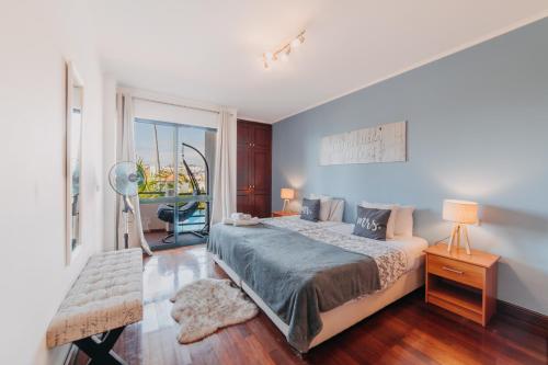 a bedroom with a large bed and a window at Funchal Lounge Apartment by Amazing Madeira in Funchal