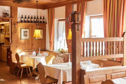 a dining room with a table and chairs and windows at Hotel Restaurant Erber in Ismaning