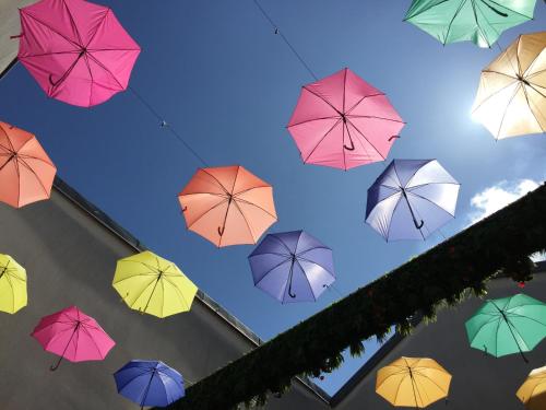 a bunch of colorful umbrellas flying in the sky at City Loft Apparthotel in Dijon