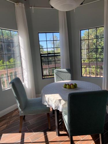een eetkamer met een tafel, stoelen en ramen bij Rancho Garden Home in Rancho Santa Fe