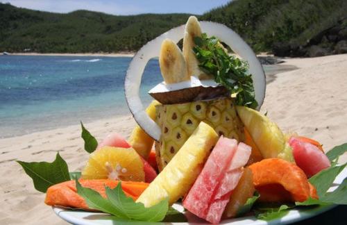 a plate of fruit and vegetables on a beach at Long Beach Escape in Vuake