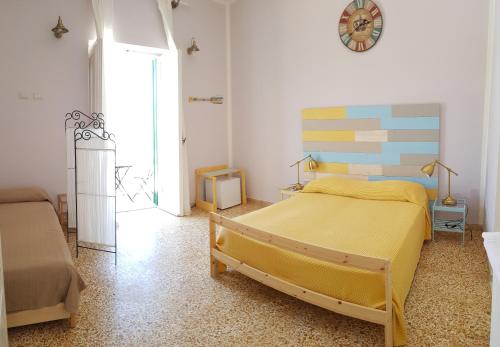 a bedroom with two beds and a clock on the wall at Maridea - Camere con vista al Porto in Ponza