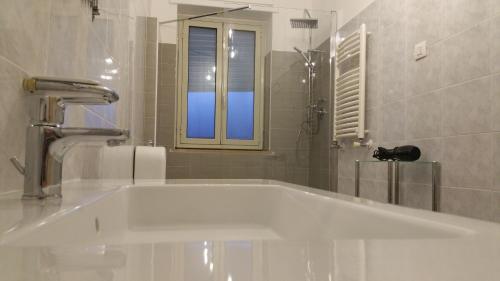 baño con bañera blanca y ventana en Appartamento Astrea, en Siracusa