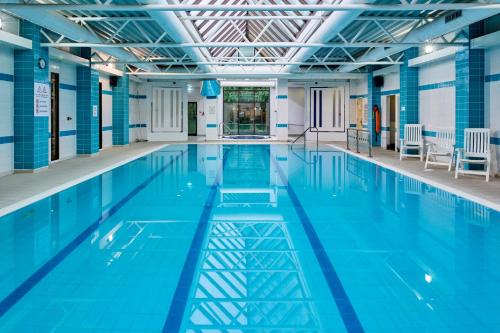 uma grande piscina com água azul em Holiday Inn Haydock, an IHG Hotel em Haydock