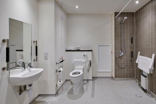 a bathroom with a toilet and a sink and a shower at Holiday Inn Haydock by IHG in Haydock