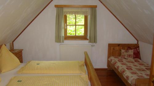 a attic room with two beds and a window at Ferienhaus Lenzau in Strohmarkt