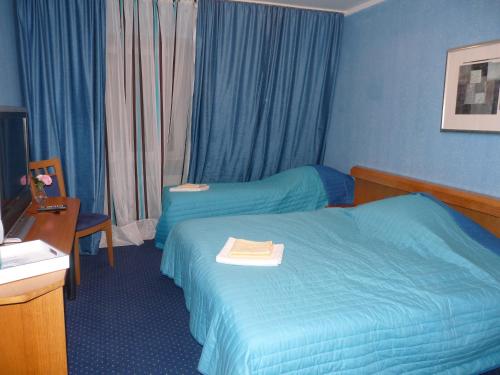 a hotel room with two beds and a desk at Kardamon in Żary