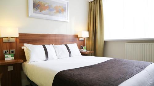 a hotel room with a large bed and a window at Holiday Inn Runcorn M56 Junction 12 by IHG in Runcorn