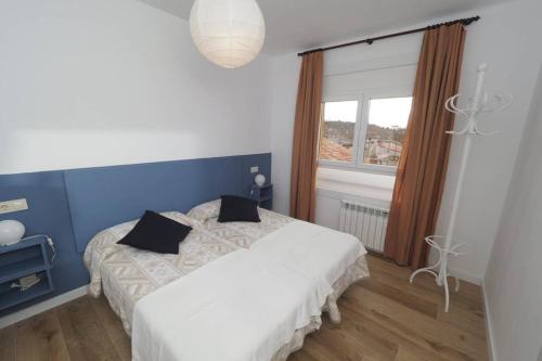 1 dormitorio con cama blanca y ventana en Apartaments Sa Calm Sant Miquel de les Formigues, en Sant Hilari Sacalm