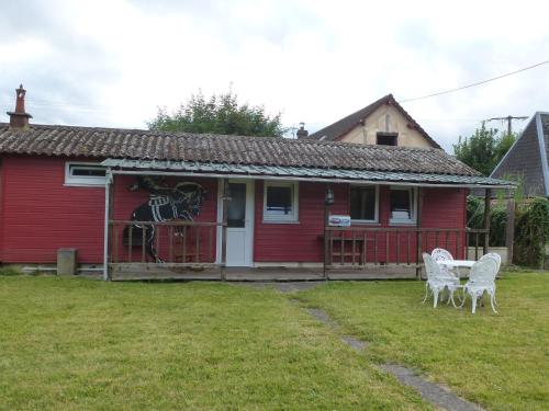 una casa roja con dos sillas blancas delante en Tiny House Westen Life, en Romilly-sur-Andelle