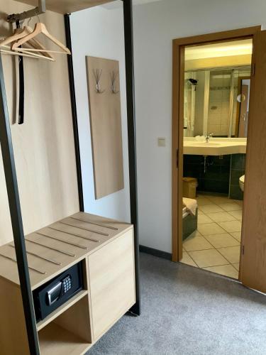 a bathroom with a tv and a mirror at Bluhm's Hotel & Restaurant am Markt in Kyritz