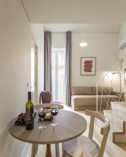 a living room with a table and two glasses of wine at LSA Santos by Numa in Lisbon
