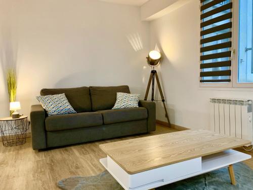 a living room with a couch and a table at La charmeraie in Compiègne