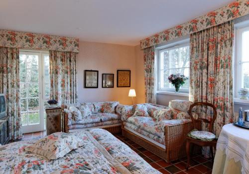 - un salon avec un canapé, un lit et des fenêtres dans l'établissement Landhaus Ettenbühl Bed and Breakfast, à Bad Bellingen