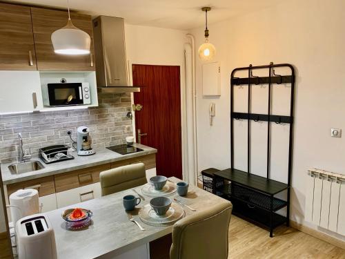 a kitchen with a table with chairs and a counter top at La charmeraie in Compiègne