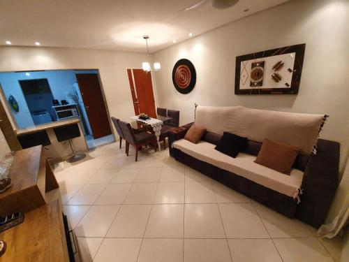 a living room with a couch and a table at Apartamento dois quartos perto da praia em Jardim Camburi in Vitória