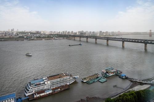 um rio com dois navios de cruzeiro e uma ponte em Holiday Inn Wuhan Riverside, an IHG Hotel em Wuhan